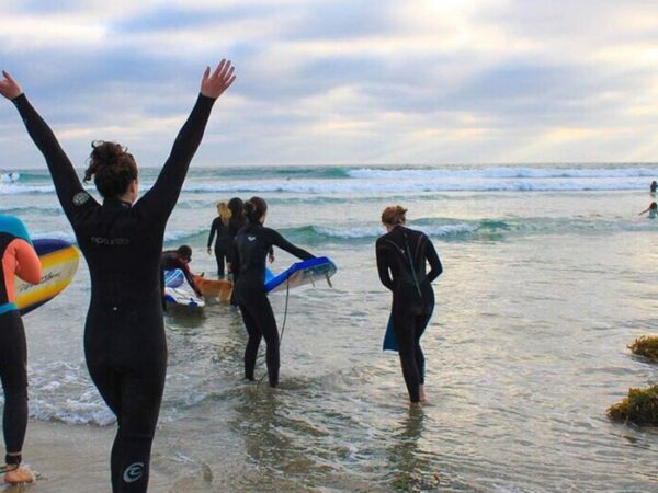 Young students learning to surf at a youth mental health surf therapy program in Sydney.